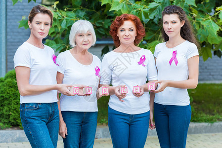 有乳腺癌意识丝带的女拿着带有癌症字样的立方图片