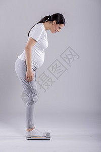 检查体重的年轻孕妇图片