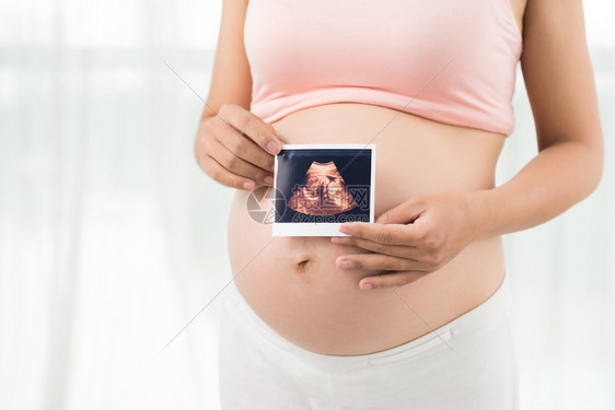 孕妇的裁剪图像显示婴儿图片