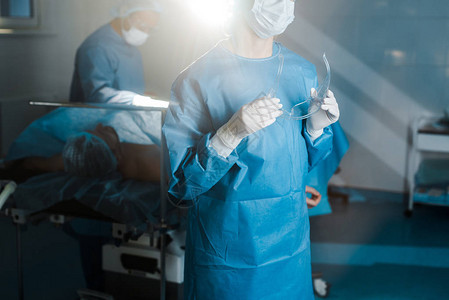 身穿制服和医疗面具在手术室戴护目镜的护图片