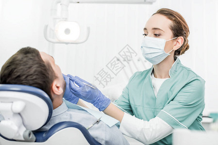 牙科诊所病人附近拿着牙科图片