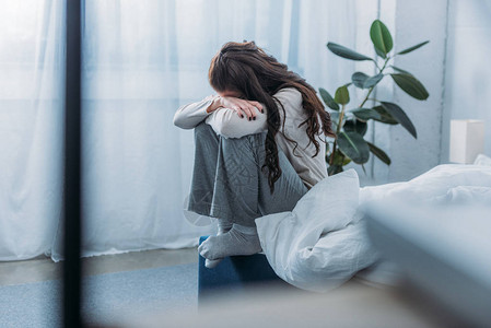 悲伤的女士坐着用双手蒙面图片