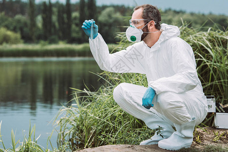 检查室外试验瓶中水样本的防护服中的男科学家图片