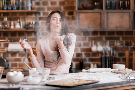 年轻女人在厨房做面粉赚图片