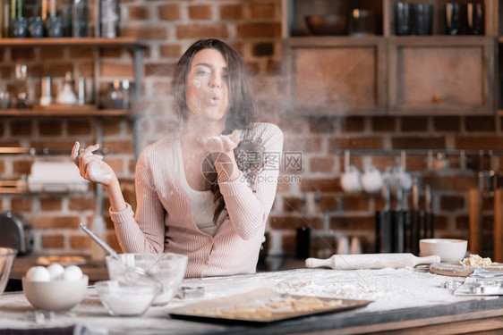 年轻女人在厨房做面粉赚图片