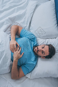 悲伤孤独的男人躺在床图片