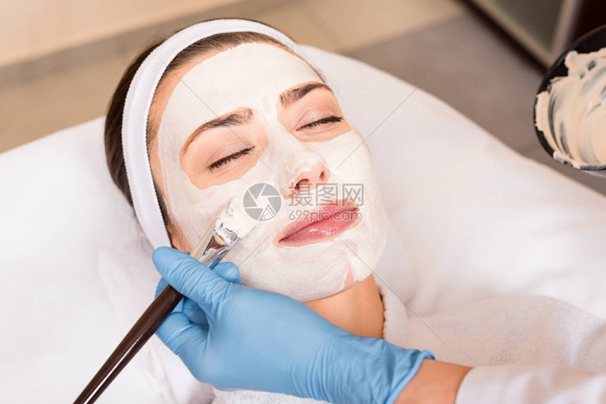 美容师在美容院用化妆面罩蒙着妇女脸图片