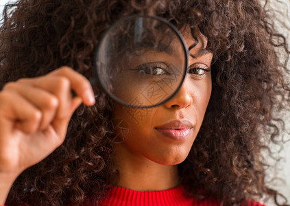 好奇的非洲美裔女透过放大镜寻找自信的智慧脸孔表情图片