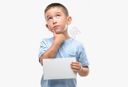 黑发小孩拿着一张空白卡片严肃的脸思考问题图片