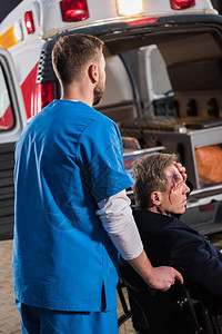 医护人员将受伤的成熟男子乘轮用救护车运图片