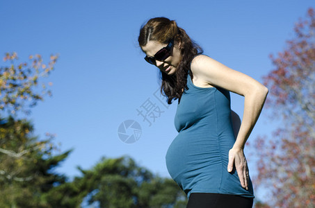 孕妇在户外怀孕期间遭受背痛女健康生活方式和保健的概念照图片