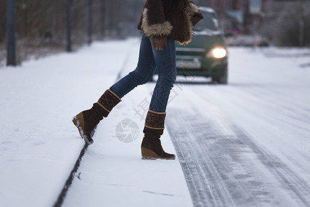 女人在车前过雪路图片