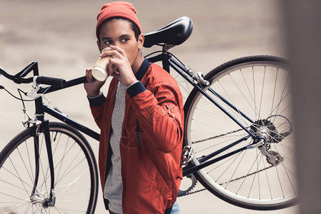 男人骑着老式自行车喝咖啡走开图片