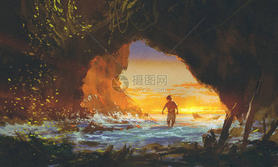 在日落时在海洞中行走的男人图片
