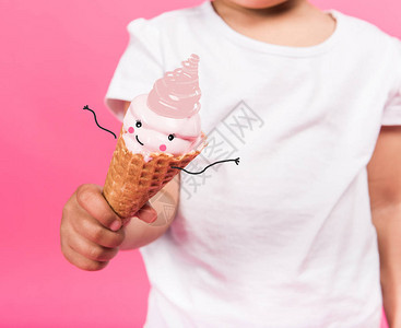学龄前儿童将冰淇淋用一只被粉红色隔开的手图片