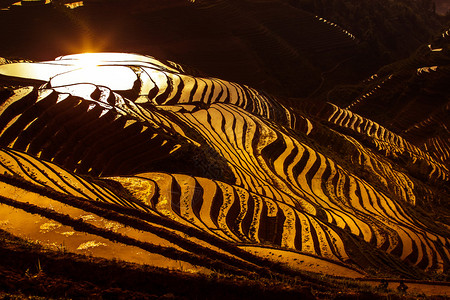 广西省瑶族少数民族村庄山谷和山丘上的日出背景图片