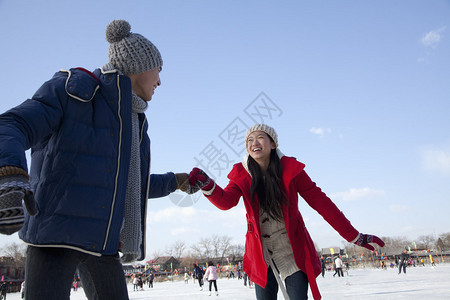 在溜冰场滑冰的年轻夫妇图片