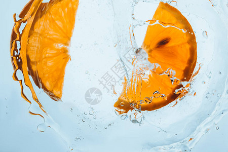 鲜橙片漂浮在水中溅起水花图片