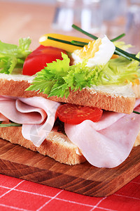 火腿三明治配菜板上的蔬菜图片
