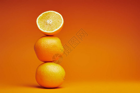 橙色背景上整个橙子和切片橙子的特写视图图片