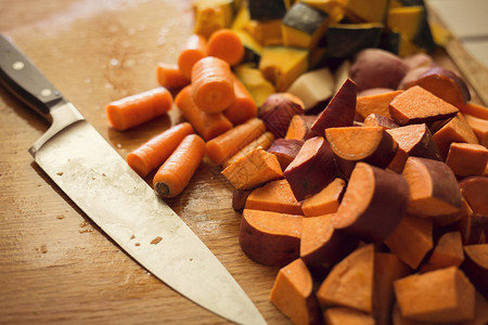 近距离观看切碎的甜土豆和胡萝卜在厨房的图片