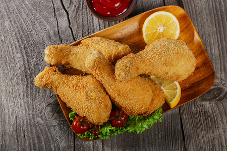 木制表面上的面包屑炸鸡腿背景图片