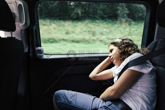 旅行时睡在汽车后座上的女少年图片