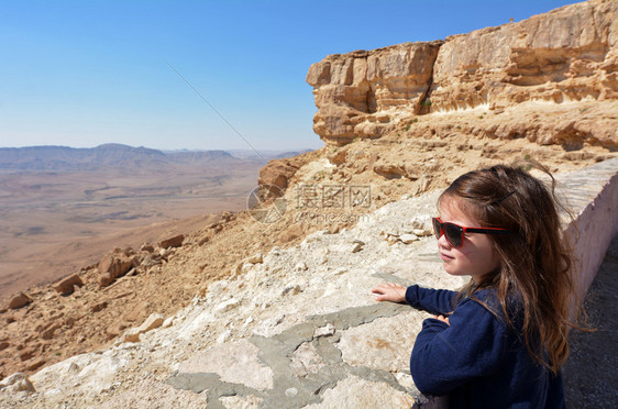 以色列小女孩看着以色列内盖夫沙漠中的MakhteshRamonRamonCrater的图片