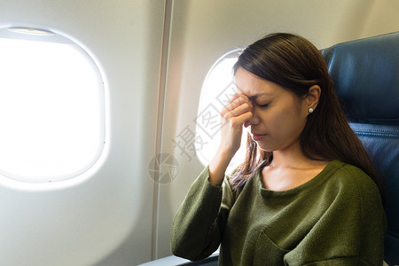 亚裔年轻女子坐在飞机图片
