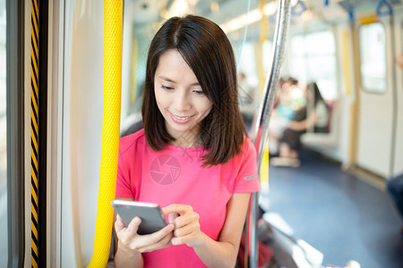 亚洲青年女子在列车厢内使用手机的图片