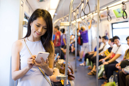 在火车厢内使用手机的女人图片