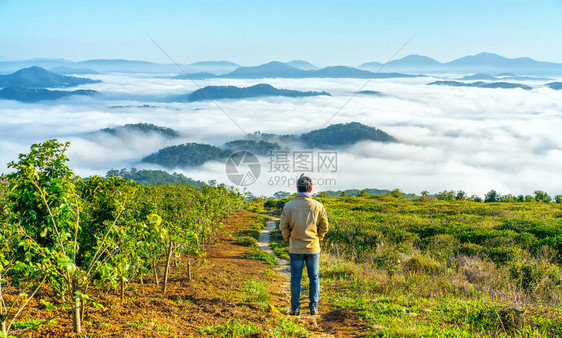 站在高山风景秀丽的农村家乡的剪影年轻人在早晨山谷雾笼罩的山脉若隐现为越南本土的图片