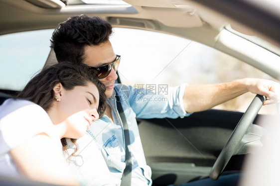 年轻男子驾驶汽车而他的女朋友图片