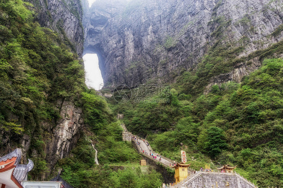 一座大水侵蚀了两座山峰之间的洞穴在Chiangjiajie的锡亚门山图片