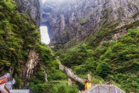 一座大水侵蚀了两座山峰之间的洞穴在Chiangjiajie的锡亚门山图片