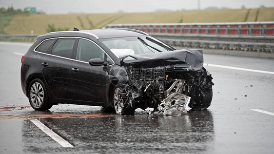 严重雨中障碍碰撞后右侧公路上的一辆汽车被损坏惨重的前面图片