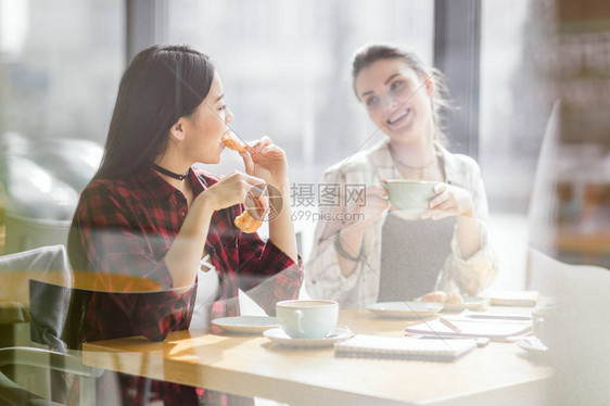 女孩在咖啡厅喝咖啡休息时吃羊图片