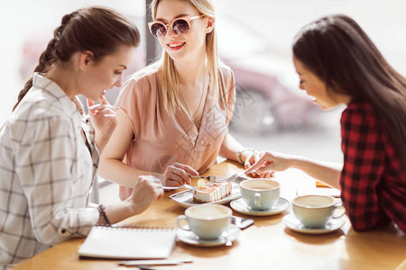 女孩们在咖啡厅喝咖啡休息时吃图片