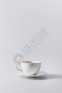 白色杯子在茶碟上加芳香咖啡以灰色隔开图片