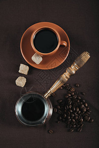 传统咖啡塔克和陶瓷杯带有棕色糖立方块和图片