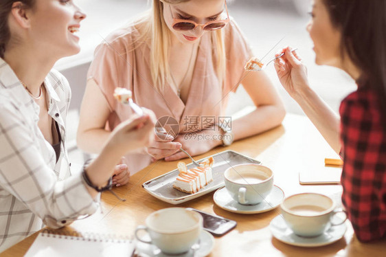 女孩们在咖啡厅喝咖啡休息时吃图片