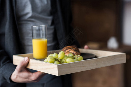 男人用早餐托盘端着餐图片