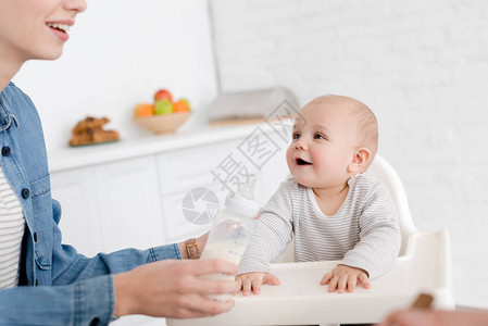 妈在厨房给小男孩喂牛奶图片