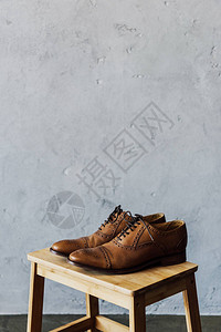 木凳上棕色皮牛津鞋的特写背景图片