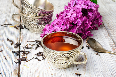 芳香的春茶时装在铁杯上和一枝开花图片
