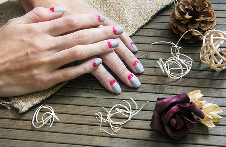 穿着灰色和粉红月亮指甲的美人手图片