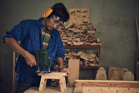 木匠在制作木椅时使用电动工具图片