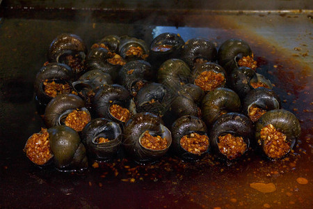使用特别煎锅中调料和口味添加剂的炸河蜗牛图片
