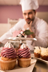 在餐厅厨房柜台上站在蛋糕附近的纸杯蛋糕和糖果店的选择焦点图片
