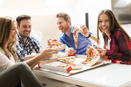 一群年轻人在房间里吃披萨图片